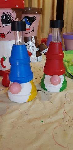 three colorful plastic cups sitting on top of a table next to each other with faces painted on them