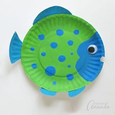 a paper plate shaped like a fish with blue dots on it's body and eyes