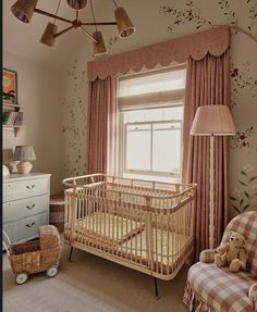 a baby's room with a crib, chair, and window in it