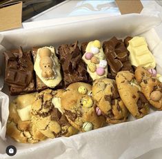 a box filled with lots of different types of cookies and chocolates on top of each other