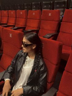 a woman sitting in an empty theater seat