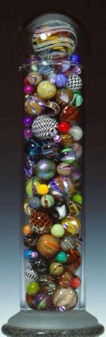 a glass vase filled with lots of different colored buttons