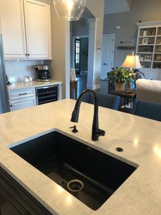 a kitchen with an island sink and black faucet