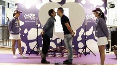 two people standing in front of an apple sign talking to each other with microphones