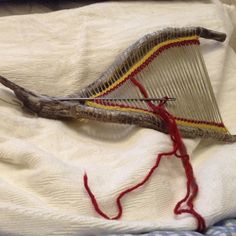 a close up of a metal object on a white cloth with red thread attached to it