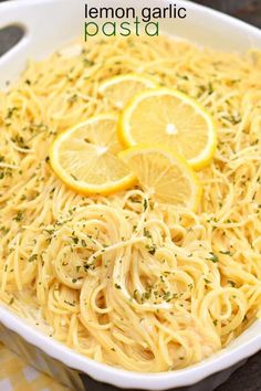 lemon garlic pasta in a white bowl with sliced lemons