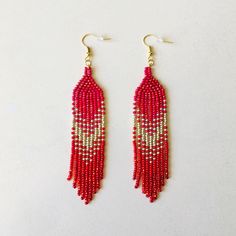 Shine bright these winter holidays wearing these long red beaded earrings with fringe. Inspired by tribal style, these statement waterfall earrings are made from high-quality Czech seed beads and supplied with stainless steel accessories. No doubt, these iridescent seed bead earrings will sparkle with every move. This pair will be a luxury addition to your Christmas look as well as a unique gift for bohemian jewelry lovers. 100% top-quality handmade earrings. Materials:  - 4 colors of Czech beads - gold color accessories. Length: 4,5'' / 11,43 cm Width: 0.8'' / 2 cm The real color of the item may be slightly different from the picture shown on website caused by the brightness of your monitor. If you have special size requirements, please send me a letter about it, as this can be made to or Red Dangle Tassel Earrings With Fringe, Red Tassel Beaded Earrings, Red Beaded Tassel Earrings, Red Beaded Tassel Drop Earrings, Red Bohemian Beaded Earrings With Tassels, Red Fringe Jewelry For Festival, Red Fringe Tassel Earrings As Gift, Red Tassel Earrings With Fringe For Gift, Red Fringe Tassel Earrings For Gift