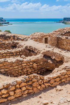 the ruins of an ancient city overlooking water and land with blue sky in the background