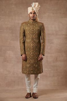 Mehendi green sherwani with floral embroidered motifs and mandarin collar. Paired with kurta and pyjama.
Components:3
Pattern:Embroidered
Type of Work:Floral
Neckline:Mandarin
Sleeve Length:Full Sleeves
Fabric:Slub Silk, Cotton Silk
Color:Green
Other Details:
Note: Head accessory worn by the model is not for sale
Occasion:Wedding - Aza Fashions Green Traditional Wear With Naqshi For Eid, Green Naqshi Traditional Wear For Eid, Festive Green Churidar With Naqshi Details, Fitted Green Jamawar Churidar, Festive Green Churidar With Naqshi, Semi-stitched Green Bollywood Sherwani, Green Naqshi Kurta For Wedding, Green Kurta With Naqshi In Traditional Drape, Green Kurta With Naqshi And Traditional Drape