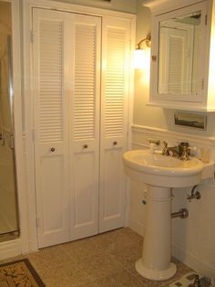 a bathroom with a sink, mirror and shower stall in the corner next to it