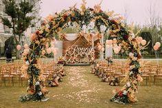 an outdoor ceremony setup with balloons and flowers on the aisle, surrounded by gold chairs