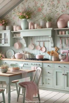 a kitchen filled with lots of pink and white dishes on top of shelves next to a wooden table