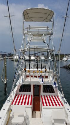 the front end of a white boat with red and white stripes on it's deck