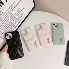 four cell phones sitting next to each other on top of a white table with a book