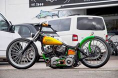 a green and yellow motorcycle parked in front of a white van