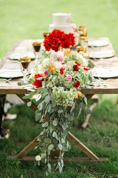 the table is set with flowers, candles and plates on it for a wedding reception