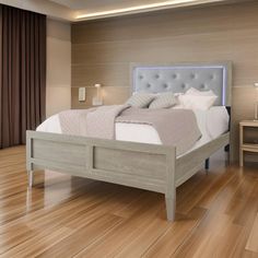 a bed sitting on top of a wooden floor next to a night stand and lamp