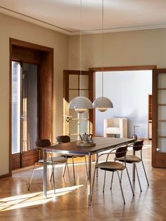 a dining room with wooden floors and white walls