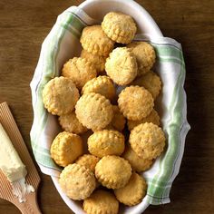 a white bowl filled with cookies next to a wooden spatula on top of a table