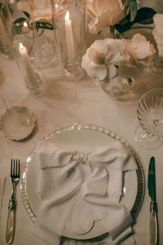 the table is set with silverware and flowers