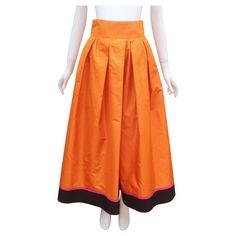 Dramatic 1980's Byblos skirt with a full ball gown style silhouette in a colorful silk blend taffeta fabric. The color combination of cantaloupe orange accented with a band of fuchsia pink and black at the hemline provides both a festive and rich aesthetic. The skirt zips at the side with inverted pleating, a wide waistband and hidden pockets. Fabulous look for hostess wear paired with anything from a silky t-shirt to an elegant taffeta blouse. There is no Byblos label at the waistband, only a ' Taffeta Blouse, Rich Aesthetic, Taffeta Skirt, Taffeta Fabric, Gown Style, Wrap Mini Skirt, Floral Maxi Skirt, Silk Taffeta, Peasant Style