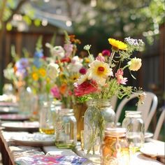 there are many vases with flowers in them on the table