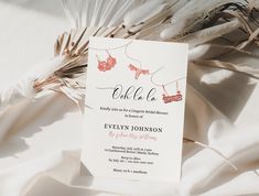 the wedding card is laying on top of some feathers