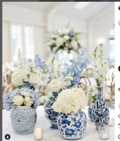 blue and white vases with flowers in them on a table