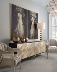 a living room with two paintings on the wall and chairs in front of each other