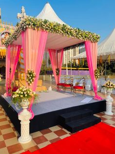 an outdoor wedding setup with pink drapes and flowers