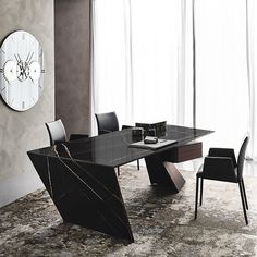 a modern dining table with black chairs and a large clock on the wall behind it