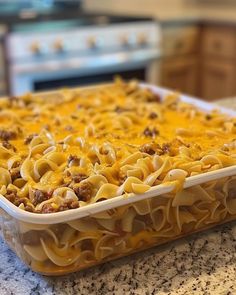 a casserole dish with cheese and meat in it sitting on a kitchen counter