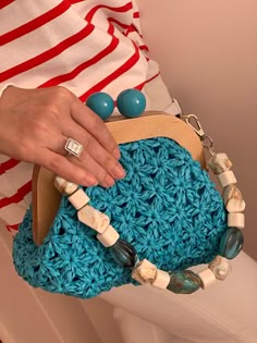 a woman is holding a crocheted purse