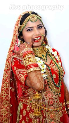 a woman dressed in red and gold poses for the camera