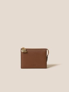 a brown leather wallet on a white background with a gold clasp and two small zippers