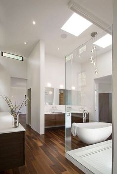 a bathroom with a large tub and wooden floors