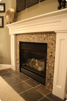 a fireplace in a living room with pictures on the wall above it and an open fire place