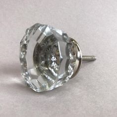 a close up of a glass knob on a white surface with a screw in the middle