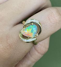 Discover a masterpiece with our custom-made 14k gold ring featuring one of the rarest opals: the Lightning Ridge crystal opal. This one-of-a-kind creation boasts a stunning 2.24 carats of opal, renowned for its vibrant play of color, enhanced by channel-set diamonds totaling .17 carats. Size 6.75 and uniquely crafted by us, this ring is a true statement of elegance and rarity. Luxury Opal Ring For Gift, Luxury Ethiopian Opal Ring As A Gift, Luxury Ethiopian Opal Ring For Gift, Luxury Ethiopian Opal Ring As Gift, Luxury Ethiopian Opal Ring Gift, Collectible Yellow Gold Opal Ring, Fine Jewelry Yellow Gold Opal Ring, Yellow Gold Opal Ring In Fine Jewelry Style, Unique Yellow Gold Opal Ring With Polished Finish