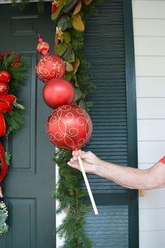 someone is holding two red ornaments in front of a door with the words, don't have a tree now and firm