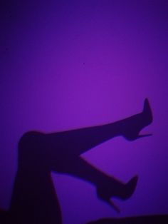 the shadow of a person's legs on a purple background