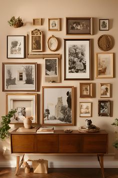 a wall full of framed pictures and photos on it's sideboard in a living room