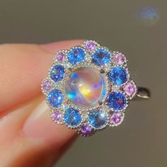 "This cocktail ring features my mini cocktail ring designed with one piece of blue sheen flawless moonstone cabochon and a fancy double halo of cornflower blue sapphires and royal blue sapphires! The size is in US 7 made of solid 14K white gold can be sized up or down for $65 if needed. This item is brand new exclusively designed by me. The certificate will be included and describes the spinel as follows: \"Shape And Cut: Cushion Cabochon Weight: 3.15 ct in total Species: Natural Moonstone Colou Wizard Jewelry, Cocktail Ring Designs, Alchemy Jewelry, Sapphire Halo Ring, Ring Moonstone, Moonstone Cabochon, Rose Gold Nails, Pink Spinel, Moonstone Engagement