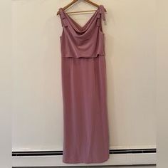 a dress hanging on a hanger in front of a wall