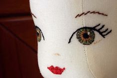 a white doll with green eyes and red lips