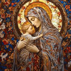 the virgin mary holding a child in her arms with colorful stained glass behind it,