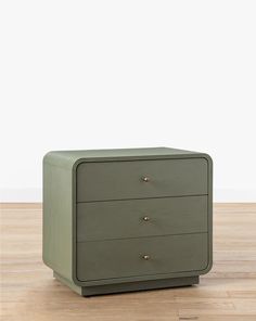 a green chest of drawers sitting on top of a hard wood floor next to a white wall