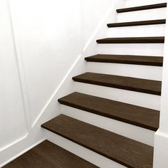 a set of wooden stairs leading up to a white wall