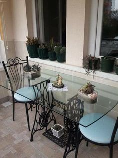 a glass table with chairs and plants on it