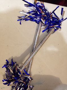 two silver and blue straws on a white table with confetti in it